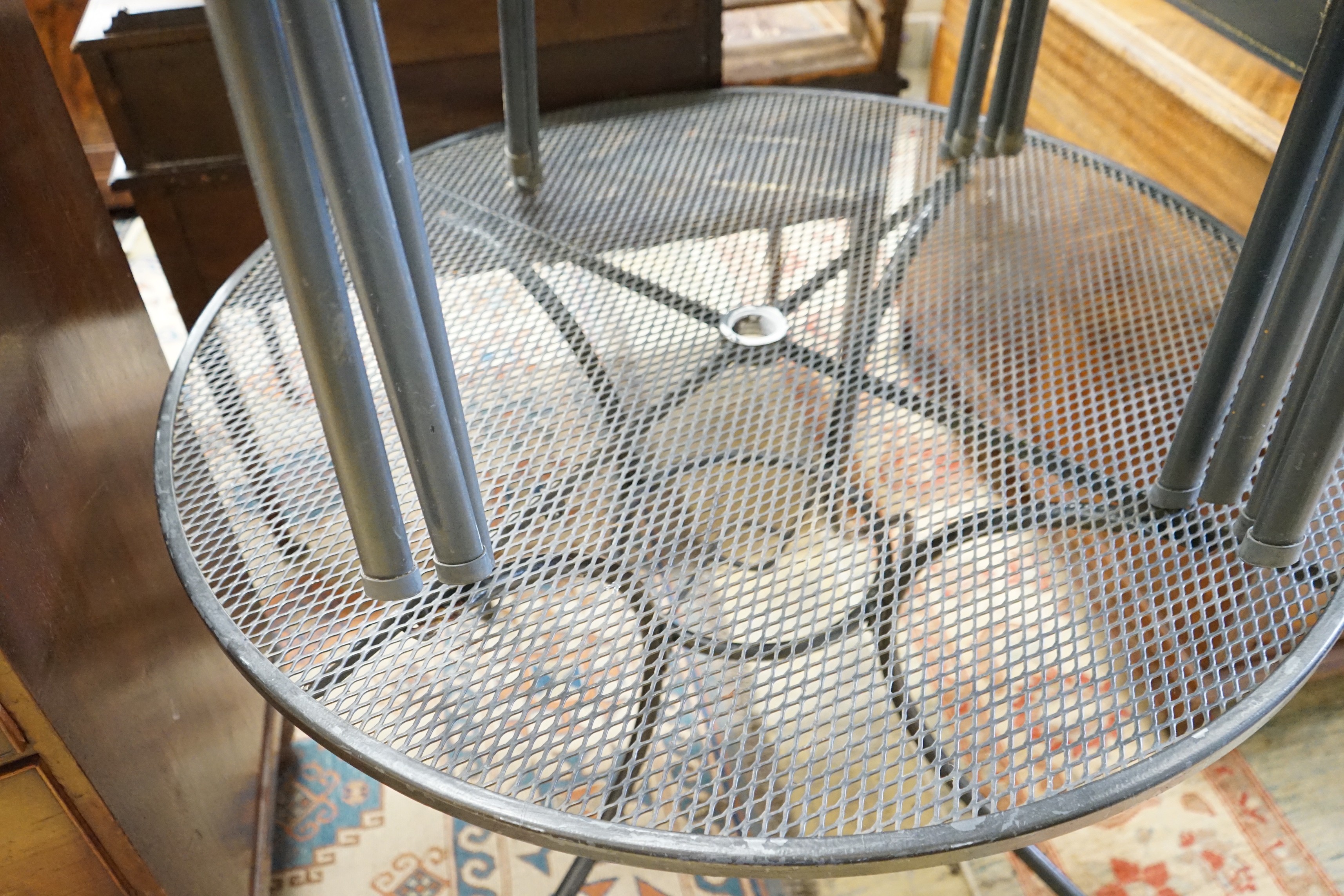A circular aluminium garden table, diameter 100cm, height 72cm and four matching stacking chairs